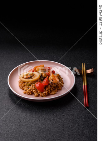 Rice and prawns or paella, a meal with seafood and vegetables. Cooked rice with shrimp 129994240