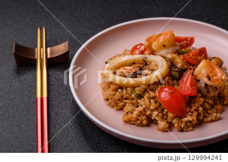 Rice and prawns or paella, a meal with seafood and vegetables. Cooked rice with shrimp 129994241
