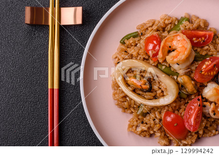 Rice and prawns or paella, a meal with seafood and vegetables. Cooked rice with shrimp 129994242