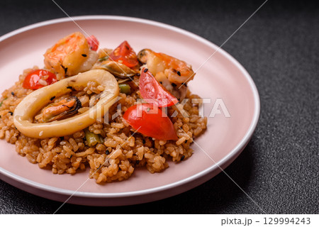 Rice and prawns or paella, a meal with seafood and vegetables. Cooked rice with shrimp 129994243