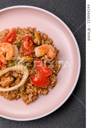 Rice and prawns or paella, a meal with seafood and vegetables. Cooked rice with shrimp Rice and prawns or paella, a meal with seafood and vegetables. Cooked rice with shrimp 129994244