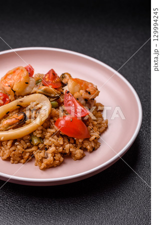 Rice and prawns or paella, a meal with seafood and vegetables. Cooked rice with shrimp Rice and prawns or paella, a meal with seafood and vegetables. Cooked rice with shrimp 129994245