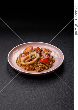 Rice and prawns or paella, a meal with seafood and vegetables. Cooked rice with shrimp 129994249