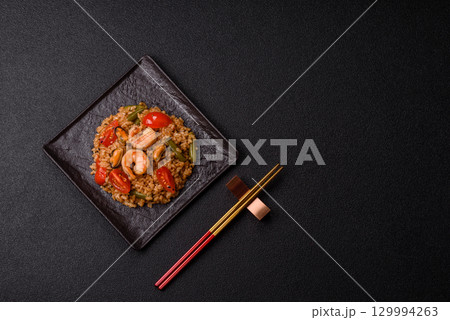 Rice and prawns or paella, a meal with seafood and vegetables. Cooked rice with shrimp 129994263