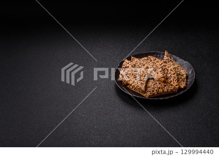 Crispbread, thin bread with seeds and grains, a baked cracker. Crispbread with sesame seeds 129994440