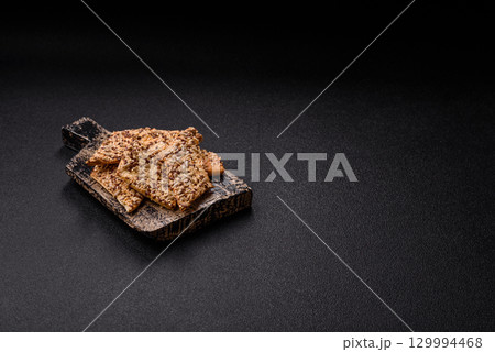 Crispbread, thin bread with seeds and grains, a baked cracker. Crispbread with sesame seeds Crispbread, thin bread with seeds and grains, a baked cracker. Crispbread with sesame seeds 129994468