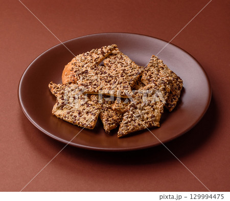 Crispbread, thin bread with seeds and grains, a baked cracker. Crispbread with sesame seeds Crispbread, thin bread with seeds and grains, a baked cracker. Crispbread with sesame seeds 129994475