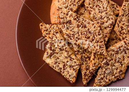 Crispbread, thin bread with seeds and grains, a baked cracker. Crispbread with sesame seeds 129994477