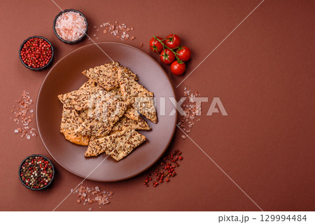 Crispbread, thin bread with seeds and grains, a baked cracker. Crispbread with sesame seeds Crispbread, thin bread with seeds and grains, a baked cracker. Crispbread with sesame seeds 129994484