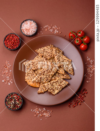 Crispbread, thin bread with seeds and grains, a baked cracker. Crispbread with sesame seeds 129994485