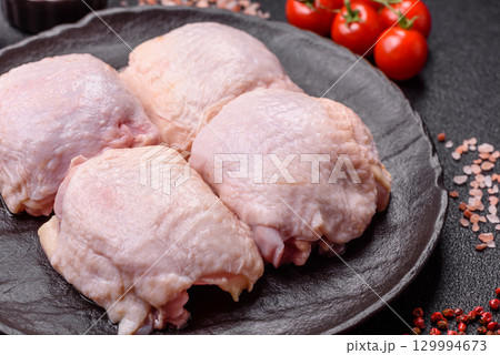 Meat, raw chicken thigh, leg in skin with salt and spices. Raw chicken thigh 129994673