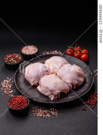 Meat, raw chicken thigh, leg in skin with salt and spices. Raw chicken thigh Meat, raw chicken thigh, leg in skin with salt and spices. Raw chicken thigh 129994680
