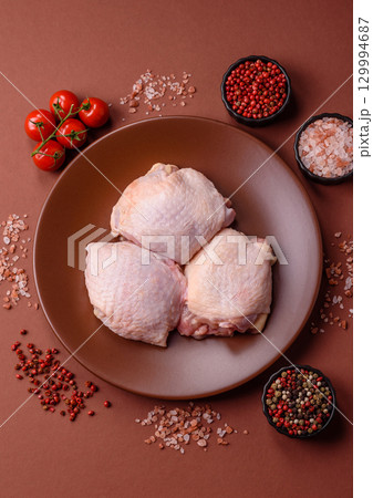 Meat, raw chicken thigh, leg in skin with salt and spices. Raw chicken thigh Meat, raw chicken thigh, leg in skin with salt and spices. Raw chicken thigh 129994687