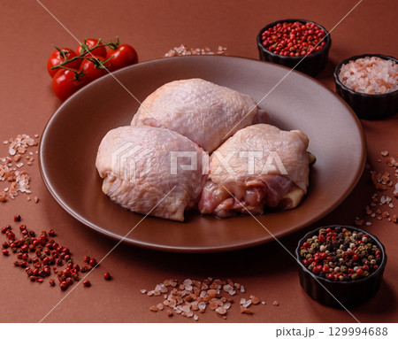 Meat, raw chicken thigh, leg in skin with salt and spices. Raw chicken thigh Meat, raw chicken thigh, leg in skin with salt and spices. Raw chicken thigh 129994688