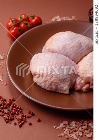 Meat, raw chicken thigh, leg in skin with salt and spices. Raw chicken thigh Meat, raw chicken thigh, leg in skin with salt and spices. Raw chicken thigh 129994692