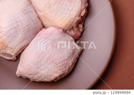 Meat, raw chicken thigh, leg in skin with salt and spices. Raw chicken thigh Meat, raw chicken thigh, leg in skin with salt and spices. Raw chicken thigh 129994694