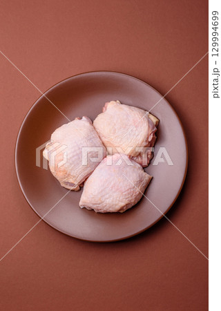 Meat, raw chicken thigh, leg in skin with salt and spices. Raw chicken thigh Meat, raw chicken thigh, leg in skin with salt and spices. Raw chicken thigh 129994699