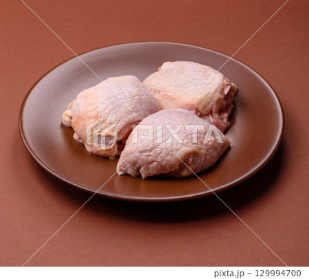 Meat, raw chicken thigh, leg in skin with salt and spices. Raw chicken thigh Meat, raw chicken thigh, leg in skin with salt and spices. Raw chicken thigh 129994700