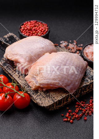 Meat, raw chicken thigh, leg in skin with salt and spices. Raw chicken thigh 129994712