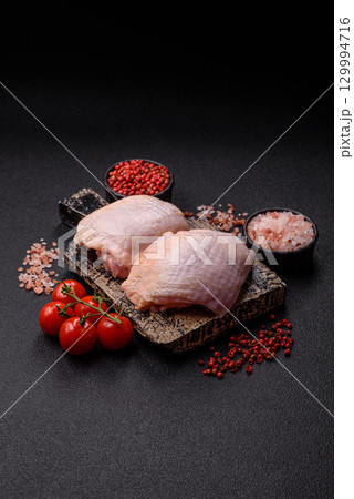 Meat, raw chicken thigh, leg in skin with salt and spices. Raw chicken thigh Meat, raw chicken thigh, leg in skin with salt and spices. Raw chicken thigh 129994716
