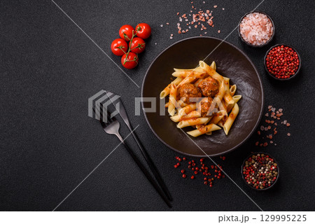 Penne pasta with meatballs in tomato sauce with salt and spices. Italian food penne pasta Penne pasta with meatballs in tomato sauce with salt and spices. Italian food penne pasta 129995225