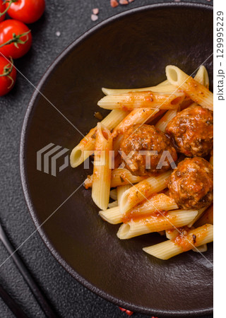 Penne pasta with meatballs in tomato sauce with salt and spices. Italian food penne pasta Penne pasta with meatballs in tomato sauce with salt and spices. Italian food penne pasta 129995229