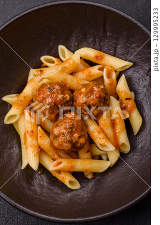 Penne pasta with meatballs in tomato sauce with salt and spices. Italian food penne pasta Penne pasta with meatballs in tomato sauce with salt and spices. Italian food penne pasta 129995233