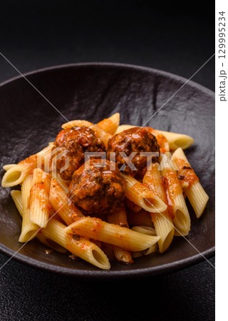 Penne pasta with meatballs in tomato sauce with salt and spices. Italian food penne pasta Penne pasta with meatballs in tomato sauce with salt and spices. Italian food penne pasta 129995234