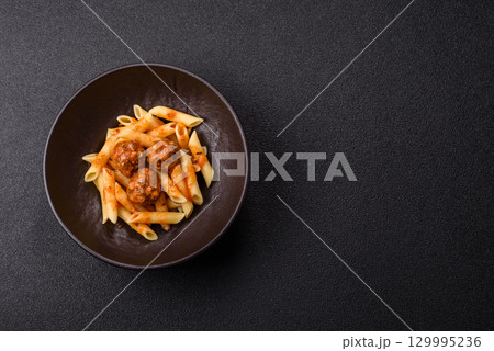 Penne pasta with meatballs in tomato sauce with salt and spices. Italian food penne pasta Penne pasta with meatballs in tomato sauce with salt and spices. Italian food penne pasta 129995236