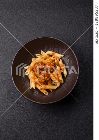 Penne pasta with meatballs in tomato sauce with salt and spices. Italian food penne pasta Penne pasta with meatballs in tomato sauce with salt and spices. Italian food penne pasta 129995237