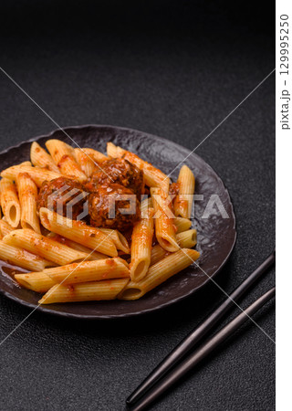 Penne pasta with meatballs in tomato sauce with salt and spices. Italian food penne pasta Penne pasta with meatballs in tomato sauce with salt and spices. Italian food penne pasta 129995250