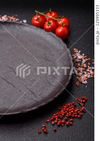 Empty round black plate for food, risotto or pasta. Empty plate on dark background 129995333