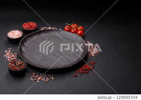 Empty round black plate for food, risotto or pasta. Empty plate on dark background Empty round black plate for food, risotto or pasta. Empty plate on dark background 129995334