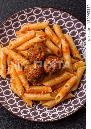 Penne pasta with meatballs in tomato sauce with salt and spices. Italian food penne pasta Penne pasta with meatballs in tomato sauce with salt and spices. Italian food penne pasta 129995350