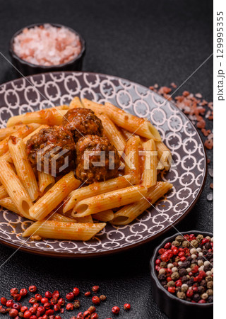 Penne pasta with meatballs in tomato sauce with salt and spices. Italian food penne pasta 129995355
