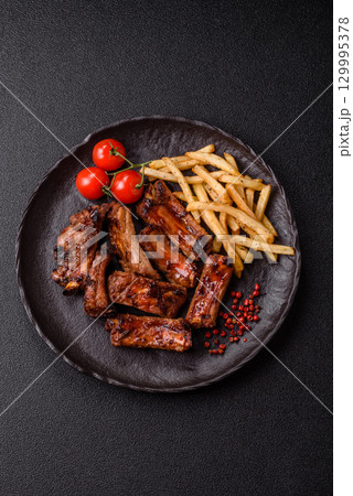 Meat, beef ribs in a marinade grilled with salt and spices. Grilled ribs Meat, beef ribs in a marinade grilled with salt and spices. Grilled ribs 129995378