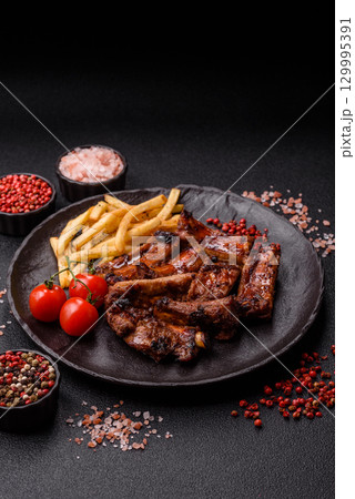 Meat, beef ribs in a marinade grilled with salt and spices. Grilled ribs Meat, beef ribs in a marinade grilled with salt and spices. Grilled ribs 129995391