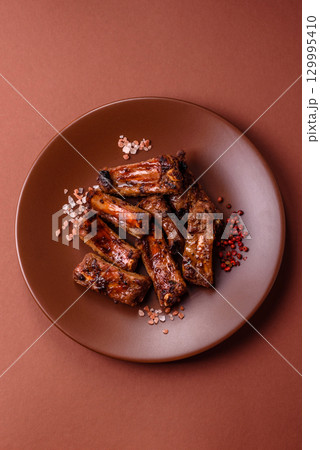 Meat, beef ribs in a marinade grilled with salt and spices. Grilled ribs Meat, beef ribs in a marinade grilled with salt and spices. Grilled ribs 129995410