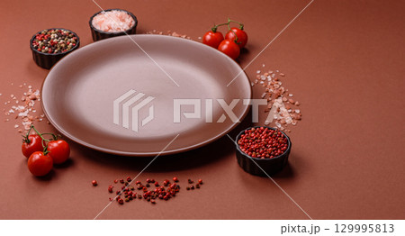 Empty ceramic plate on a monochrome brown background Empty ceramic plate on a monochrome brown background 129995813