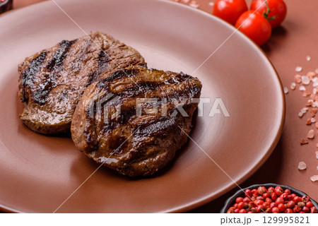 Grilled beef steak meat with salt and pepper. Beef steak grilled on a barbecue 129995821