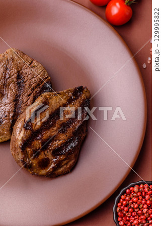 Grilled beef steak meat with salt and pepper. Beef steak grilled on a barbecue 129995822