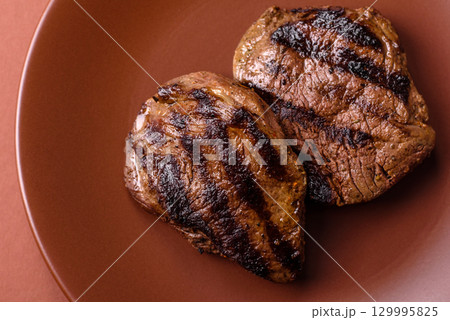 Grilled beef steak meat with salt and pepper. Beef steak grilled on a barbecue Grilled beef steak meat with salt and pepper. Beef steak grilled on a barbecue 129995825