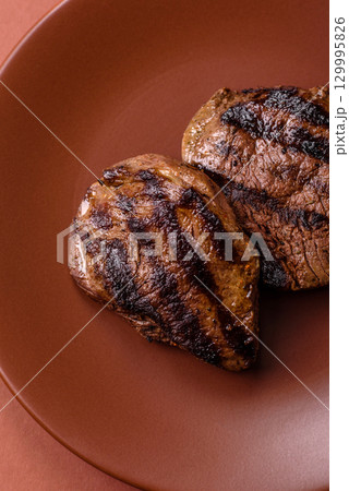 Grilled beef steak meat with salt and pepper. Beef steak grilled on a barbecue 129995826