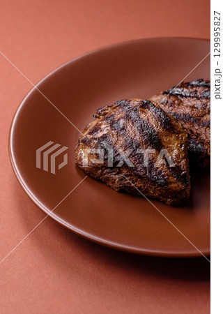 Grilled beef steak meat with salt and pepper. Beef steak grilled on a barbecue Grilled beef steak meat with salt and pepper. Beef steak grilled on a barbecue 129995827