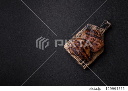 Grilled beef steak meat with salt and pepper. Beef steak grilled on a barbecue 129995833