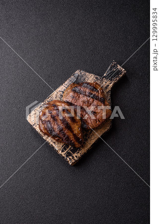Grilled beef steak meat with salt and pepper. Beef steak grilled on a barbecue 129995834