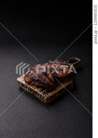 Grilled beef steak meat with salt and pepper. Beef steak grilled on a barbecue 129995835