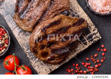 Grilled beef steak meat with salt and pepper. Beef steak grilled on a barbecue 129995840