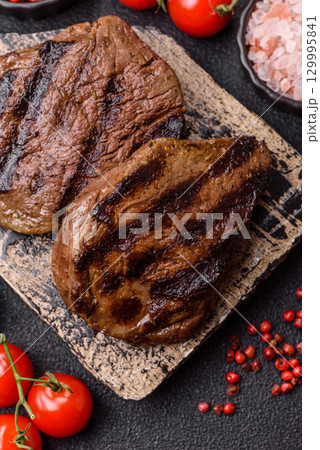 Grilled beef steak meat with salt and pepper. Beef steak grilled on a barbecue Grilled beef steak meat with salt and pepper. Beef steak grilled on a barbecue 129995841