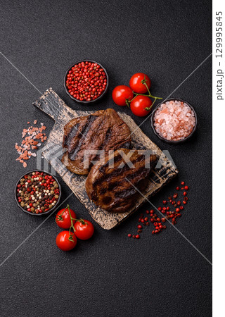 Grilled beef steak meat with salt and pepper. Beef steak grilled on a barbecue Grilled beef steak meat with salt and pepper. Beef steak grilled on a barbecue 129995845